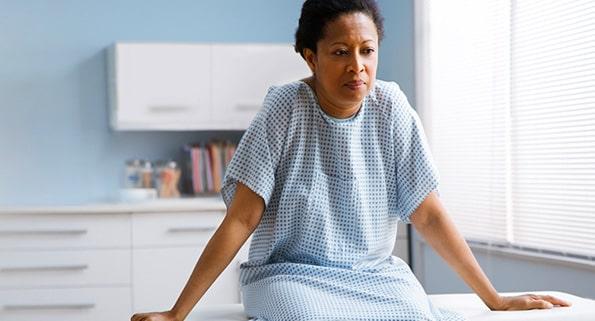 woman in medical gown on examination table