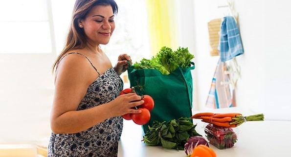 woman unbagging heart healthy groceries