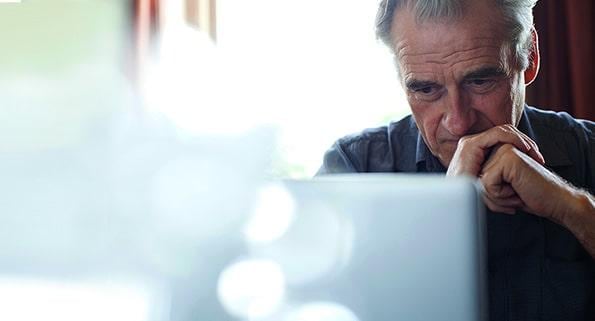 older man looking at laptop screen
