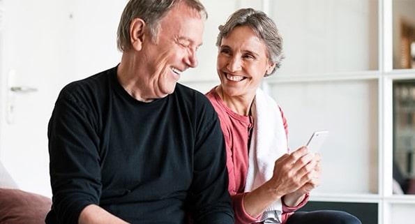 older couple sitting on a couch laughing
