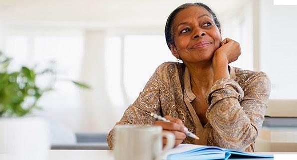 african american woman writing in notebook