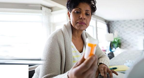 african american woman looking at a prescription bottle