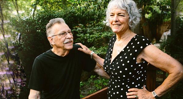 elderly man and woman standing on an outdoor deck